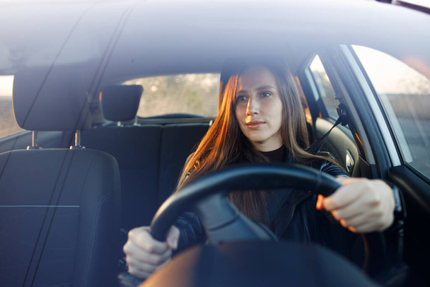 Young woman driving rented car in the evening - Foto, immagini