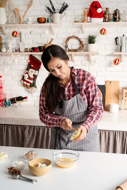 Μαγείρεμα και μαγείρεμα. Νεαρή Λατίνα γυναίκα ρίχνει το μέλι στη ζύμη μαγειρεύοντας στην κουζίνα - Φωτογραφία, εικόνα