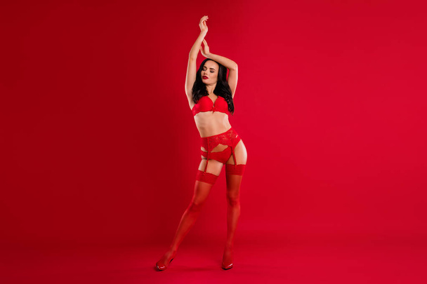 Full length photo of stunning sexy dreamy young woman raise hands pose closed eyes xmas isolated on red color background - Photo, Image