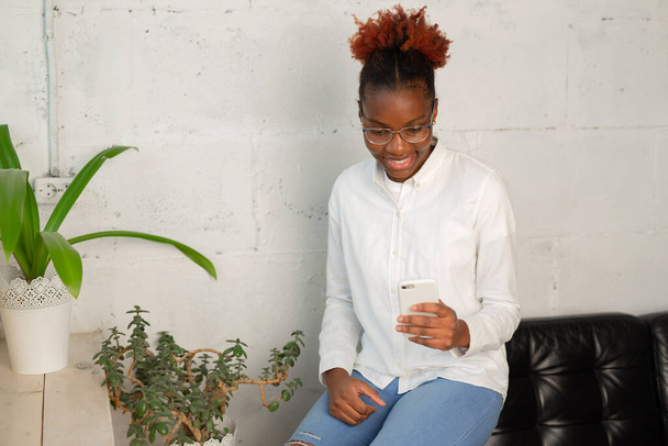 beautiful young african female in white shirt with mobile phone - Foto, Imagen