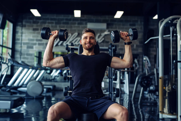 Close Up of a muscular young man lifting weights in gym - Zdjęcie, obraz
