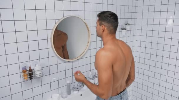 hombre sin camisa bailando y cantando cerca del espejo en el baño  - Imágenes, Vídeo