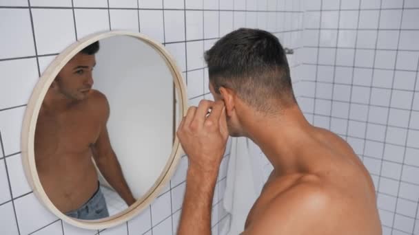 szakállas férfi néz tükör, miközben tisztít fül pamut tamponnal  - Felvétel, videó
