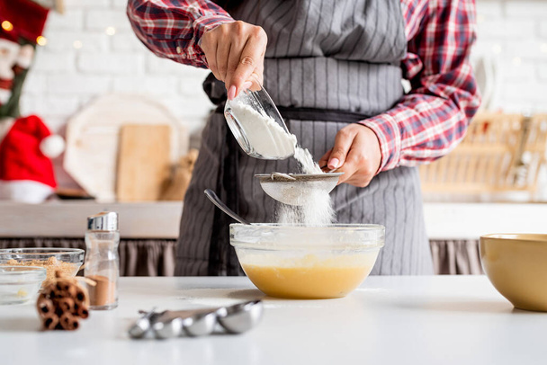 Gotowanie i pieczenie. Młoda Latynoska wylewa mąkę do ciasta w kuchni - Zdjęcie, obraz