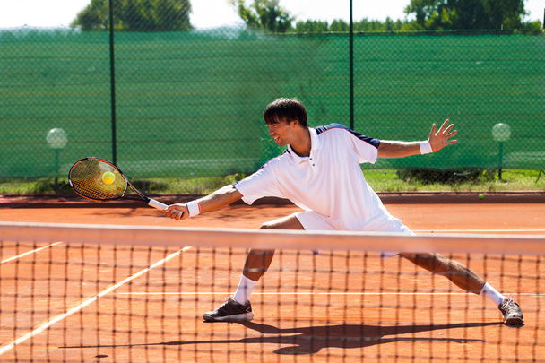 Young man playing tennis - Foto, afbeelding