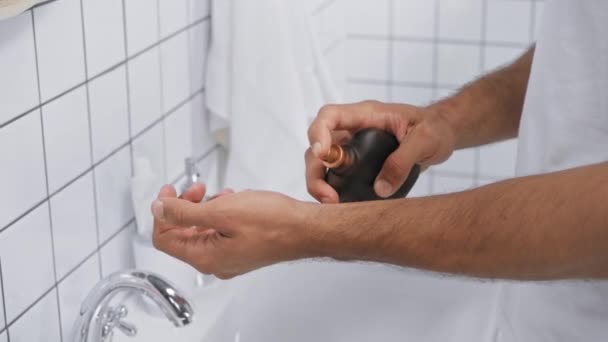 gedeeltelijk zicht op de mens spuiten aromatische parfum bij de hand in de badkamer - Video