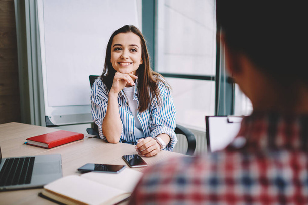 Selective focus on successful woman listening male colleague during positive conversation in office, back view of man on frontage and smart casual female trainee have recruitment interview - 写真・画像