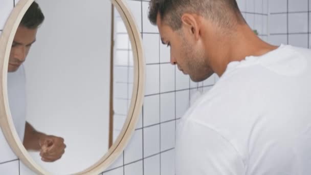 εστίαση έλξης του ανθρώπου οδοντικό νήμα κοντά στον καθρέφτη στο μπάνιο  - Πλάνα, βίντεο
