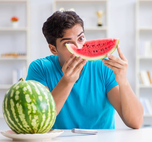 Mann isst Wassermelone zu Hause - Foto, Bild