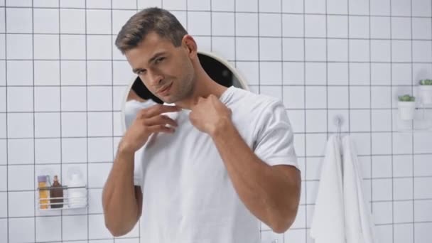 izmos férfi leveszi fehér póló és dobás közben a kamerába - Felvétel, videó