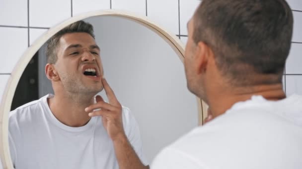 hombre tocando la cara y sufriendo de dolor de muelas en el baño  - Metraje, vídeo