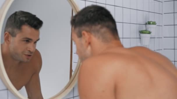 foco rack do homem olhando para o espelho no banheiro  - Filmagem, Vídeo