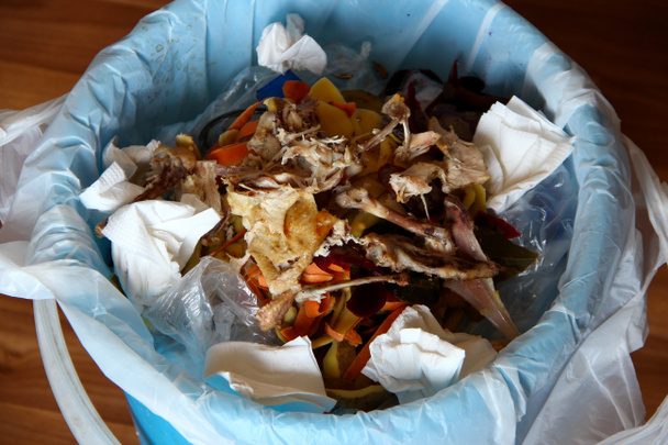 Мусорная корзина на кухне с остатками еды - Фото, изображение