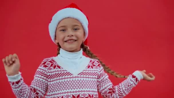 triest meisje in santa hoed en kerst trui geïsoleerd op rood - Video
