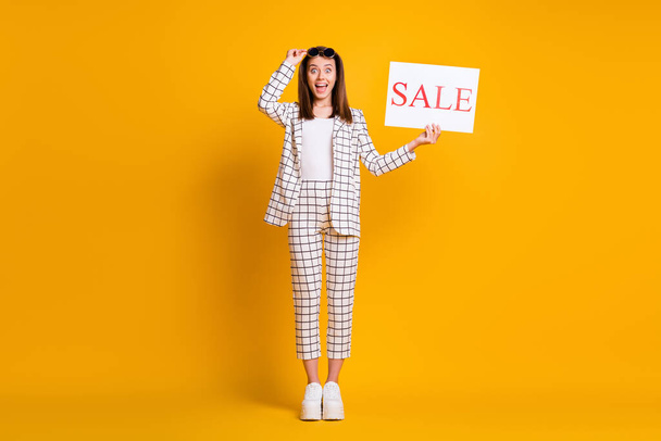Full length body size photo of shocked amazed girl keeping sale sign taking off sunglass staring smiling isolated on vivid color background - Fotografie, Obrázek