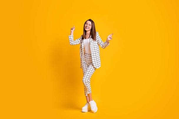 Full length body size photo of dancing woman wearing round eyeglasses enjoying music isolated on bright yellow color background - 写真・画像