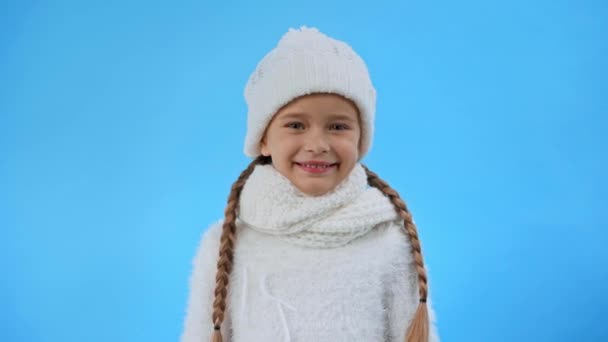 szczęśliwa dziewczyna w dzianiny biały strój zimowy przytulanie pluszowy miś izolowany na niebiesko - Materiał filmowy, wideo