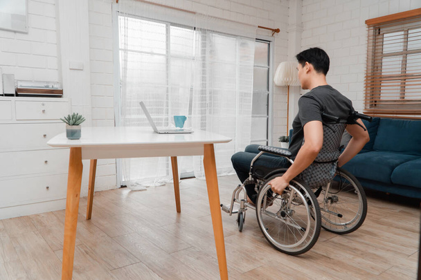 Een Aziatische gehandicapte man zit in een rolstoel is gestrest en teleurgesteld Na een auto-ongeluk, Het concept van nalatigheid en de effecten van dronken rijden - Foto, afbeelding