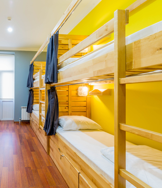 Hostel dormitory beds arranged in room - Fotó, kép