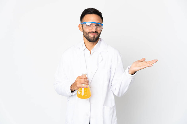 Young scientific man isolated on white background having doubts while raising hands - Photo, Image