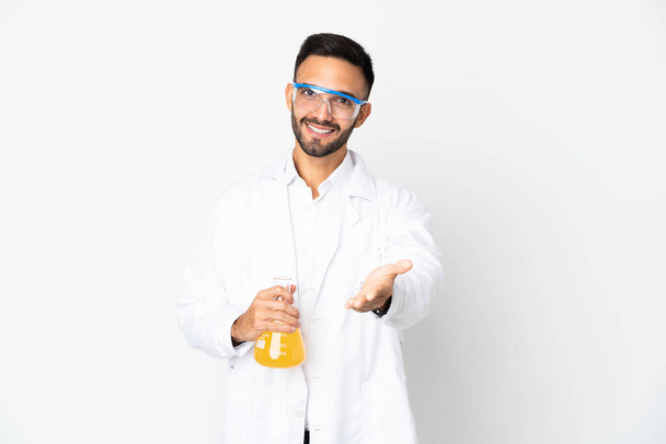 Young scientific man isolated on white background shaking hands for closing a good deal - Photo, Image