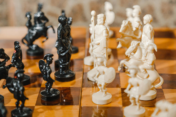 Во время шахматной игры на борту стоят белые и черные шахматные фигуры - Фото, изображение