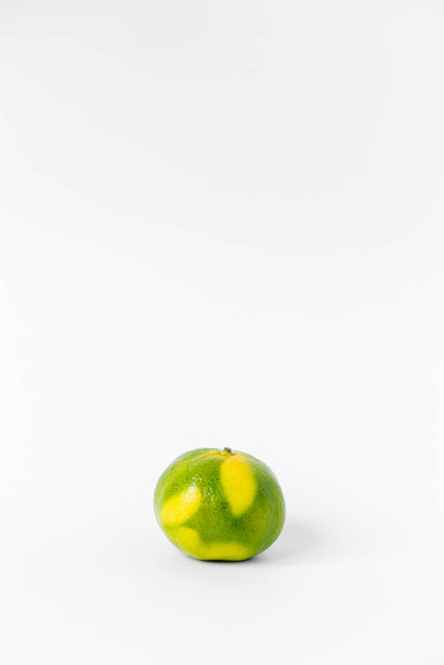 orange and lime and Ripe green and yellow tangerines and orange tangerine slices on a white background - Foto, imagen