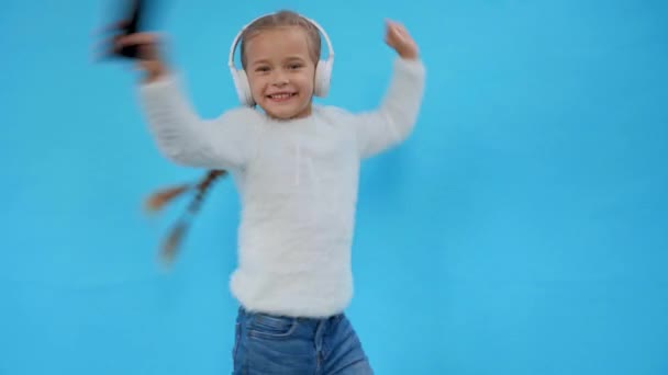 lány bolyhos pulóver tánc fülhallgató elszigetelt kék - Felvétel, videó