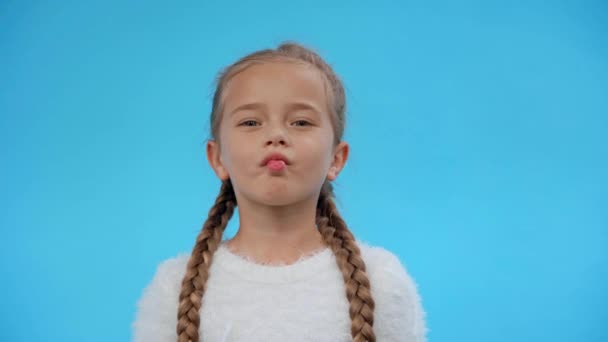lány bolyhos pulóver grimaszoló elszigetelt kék - Felvétel, videó