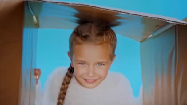 lachend meisje in pluizig trui holding box geïsoleerd op blauw - Video