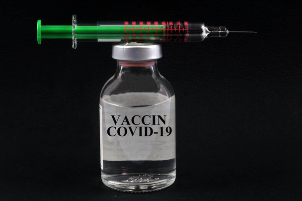 Francuska koncepcja szczepionki przeciw wirusowi covid-19 z fiolką i strzykawką na czarnym tle - Zdjęcie, obraz