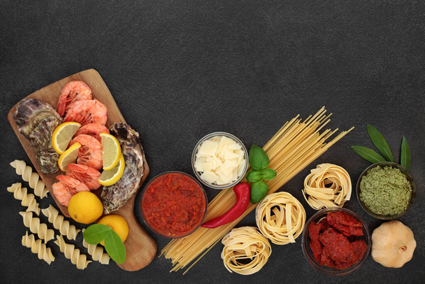 Healthy Italian balanced diet food with foods high in antioxidants, anthocyanins, lycopene, protein, omega 3 and fibre with seafood, pasta, sauces vegetables, herbs & parmesan cheese. Low cholesterol.  - Photo, Image