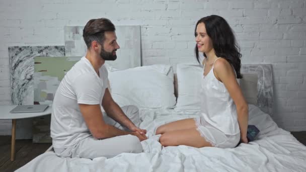 donna felice si nasconde presente dietro la schiena vicino fidanzato sul letto - Filmati, video