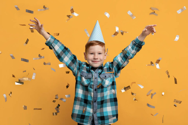 Roztomilý chlapeček slaví narozeniny přes žluté pozadí studia - Fotografie, Obrázek
