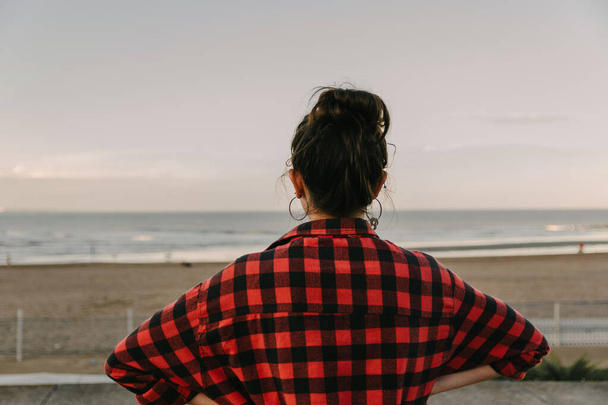 A back view of a young caucasian female in a red plaid shirt - Фото, зображення