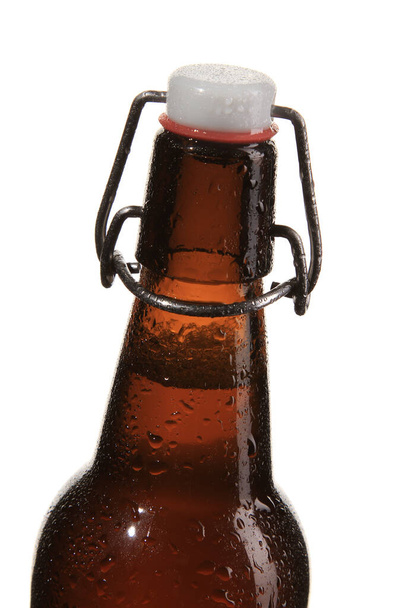 A vertical shot of a wet beer bottle isolated on a white background - Foto, imagen