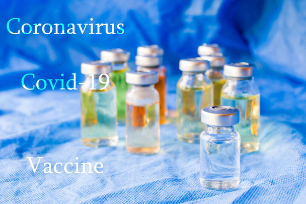 Ιός Corona και Covid - 19 νέο εμβόλιο σε αμπούλες, διαφορετικές χρωματικές παραλλαγές του εμβολίου στο μπλε φόντο - Φωτογραφία, εικόνα