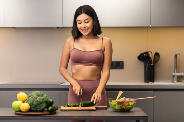 Skinny Asian Woman Cooking Preparing Healthy Dinner Standing In Kitchen - 写真・画像