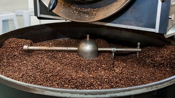 A closeup shot of coffee beans being roasted in a roaster - Fotoğraf, Görsel
