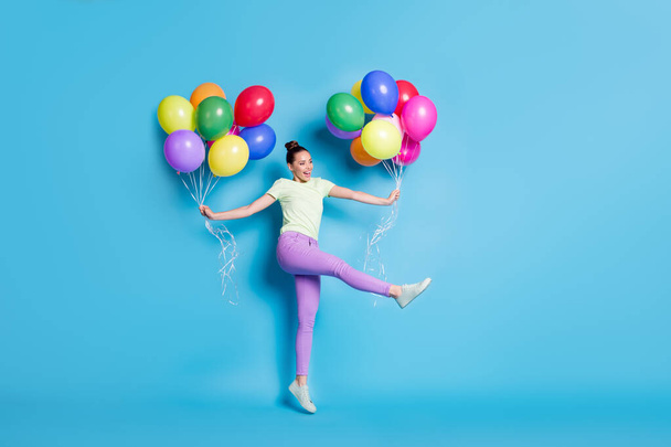 Full length body size photo of funny girl jumping keeping air balloons dancing laughing isolated on bright blue color background - Photo, Image