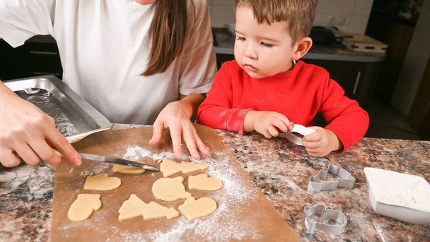 Matka i dziecko robią noworoczne ciasteczka. Wysokiej jakości zdjęcie - Zdjęcie, obraz