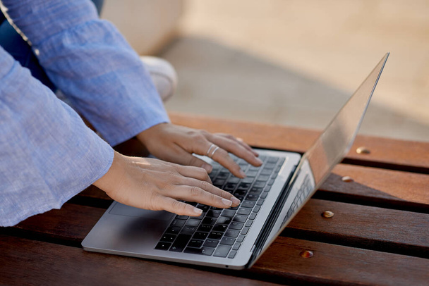 Молодая женщина вручную печатает с ноутбуком в естественном свете - Фото, изображение