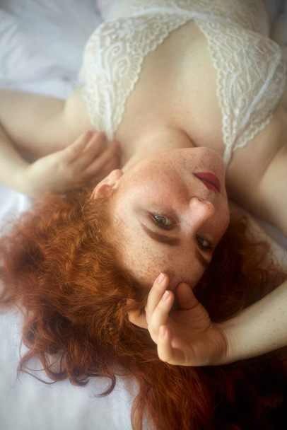 portrait of dreamy relaxed plump caucasian female on bed - Foto, Imagem