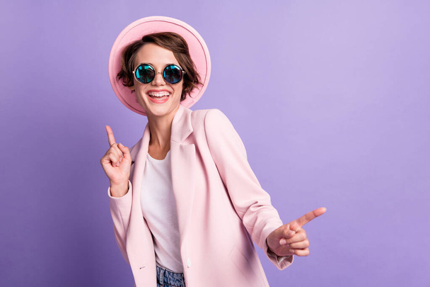Photo of funny pretty young woman dancing wear coat hat glasses top isolated on purple color background - Fotoğraf, Görsel