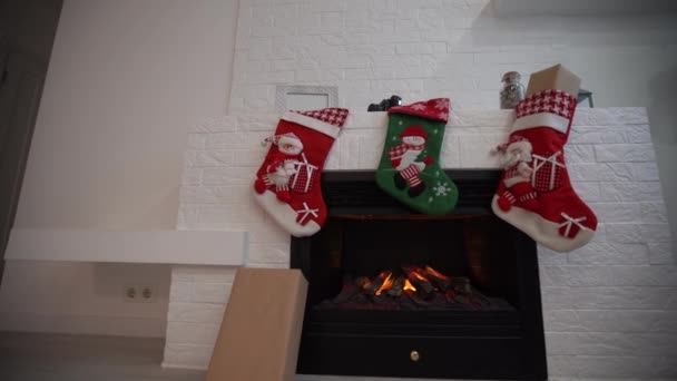 Interior de la sala de estar con chimenea calcetines decorados para Navidad - Metraje, vídeo