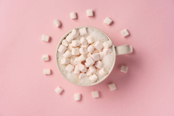  A cup of coffee with marshmallows on pink background, marshmallows lie around in the form of clock. - Photo, image