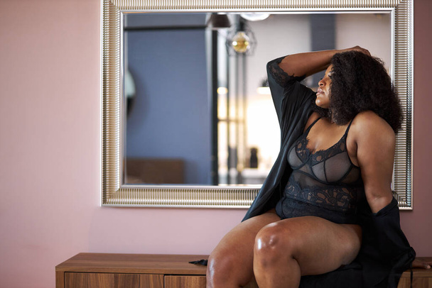 side view on overweight african woman sitting on table in underwear - Foto, Imagen