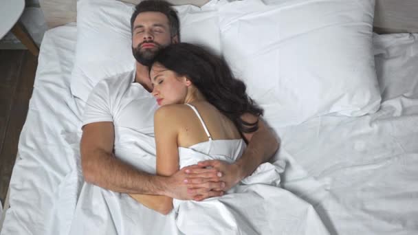 πάνω όψη του άνδρα αγκαλιάζει μελαχρινή γυναίκα, ενώ κοιμάται στο κρεβάτι - Πλάνα, βίντεο
