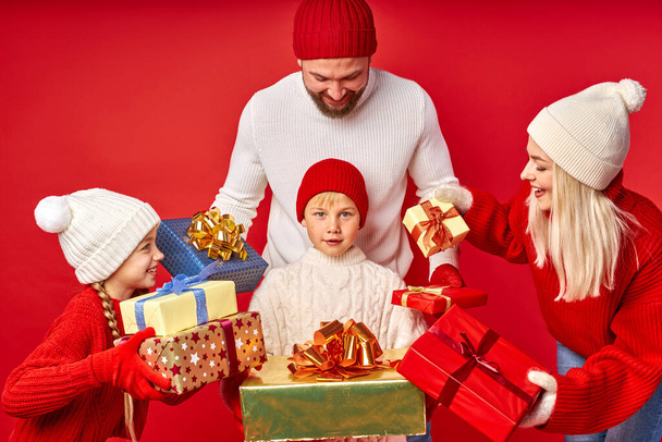 cheerful kid boy get Xmas gifts from parents and sister - Foto, imagen