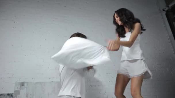 ευτυχισμένη νεαρή γυναίκα και ο άνθρωπος μαξιλάρι αγωνίζονται στην κρεβατοκάμαρα  - Πλάνα, βίντεο